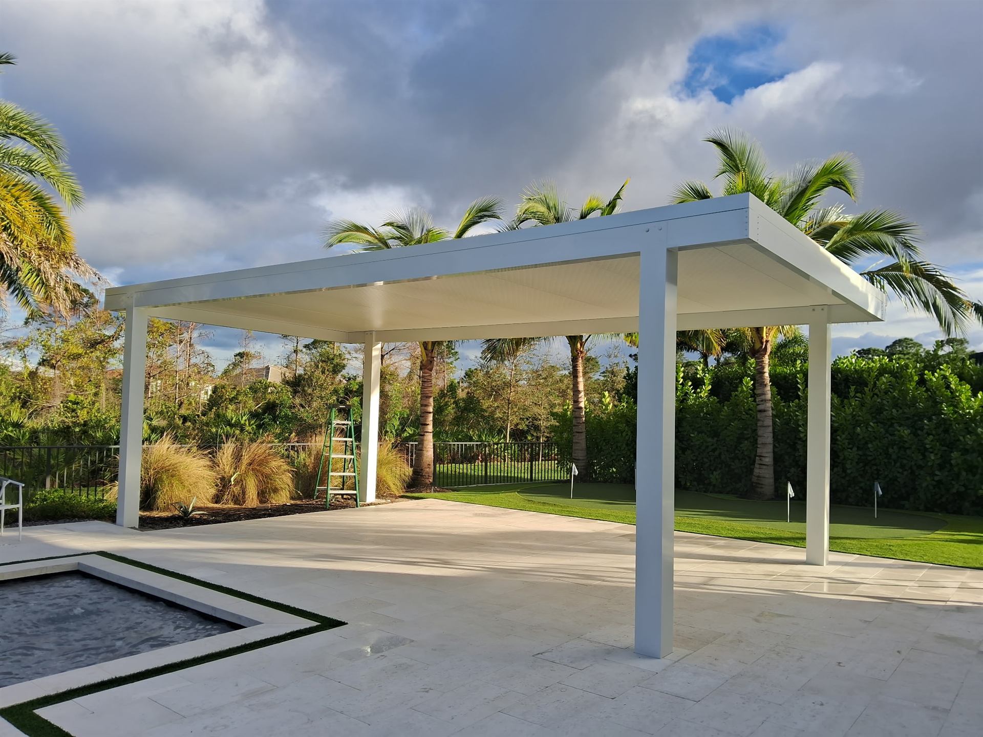 Freestanding white aluminum pergola overlooking a putting green