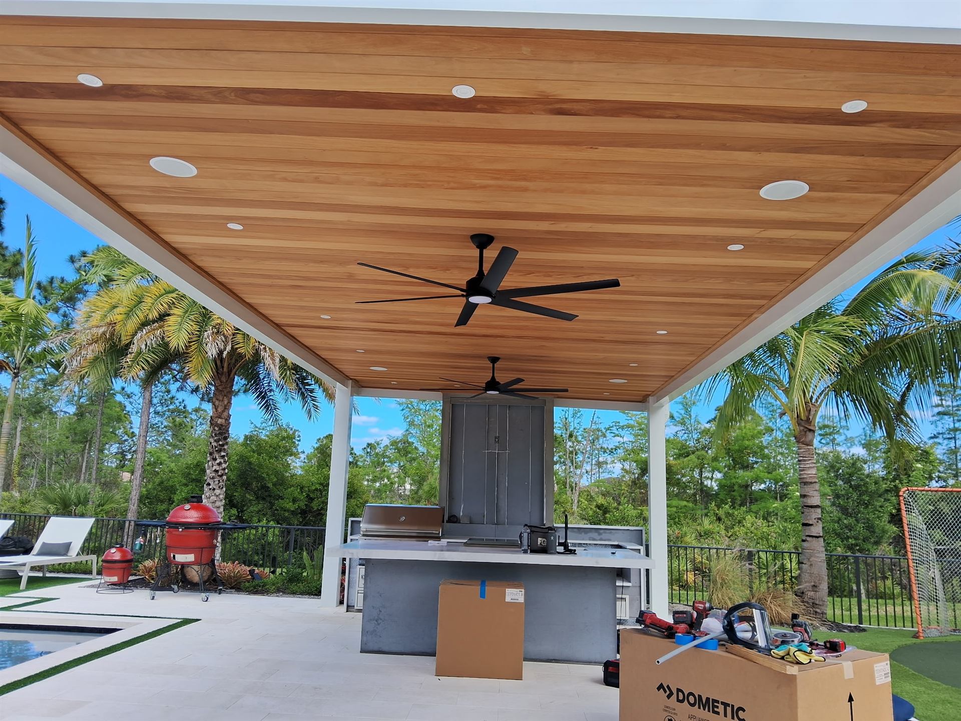 Custom aluminum pergola with wood ceiling and integrated outdoor kitchen