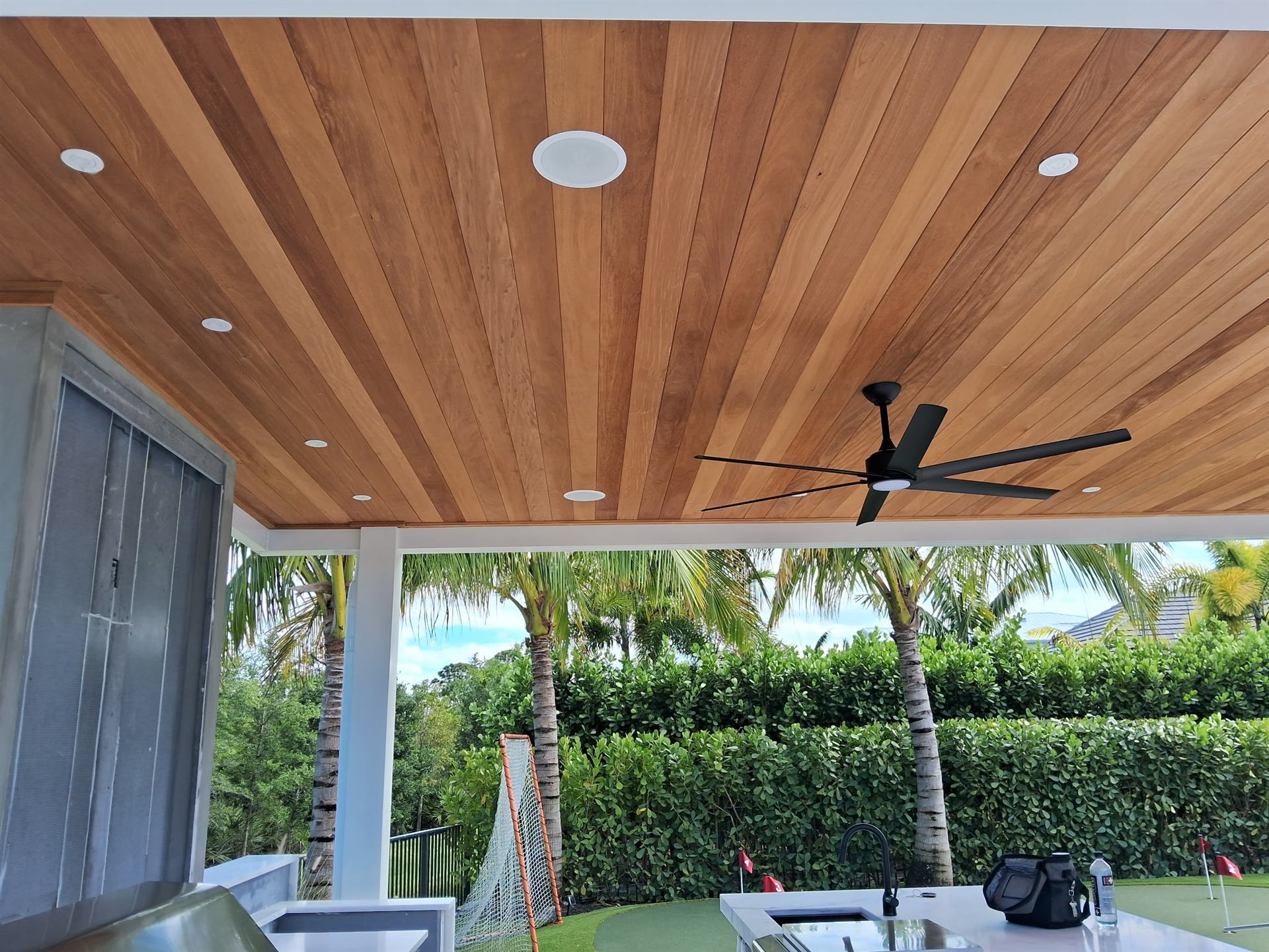 Wood ceiling detail of an aluminum pergola with recessed lighting
