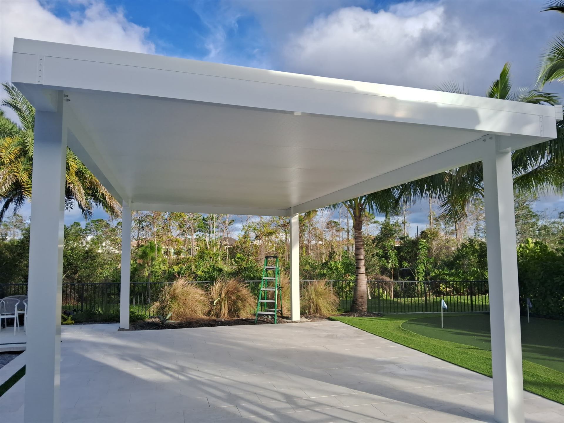 Freestanding white aluminum pergola beside a swimming pool