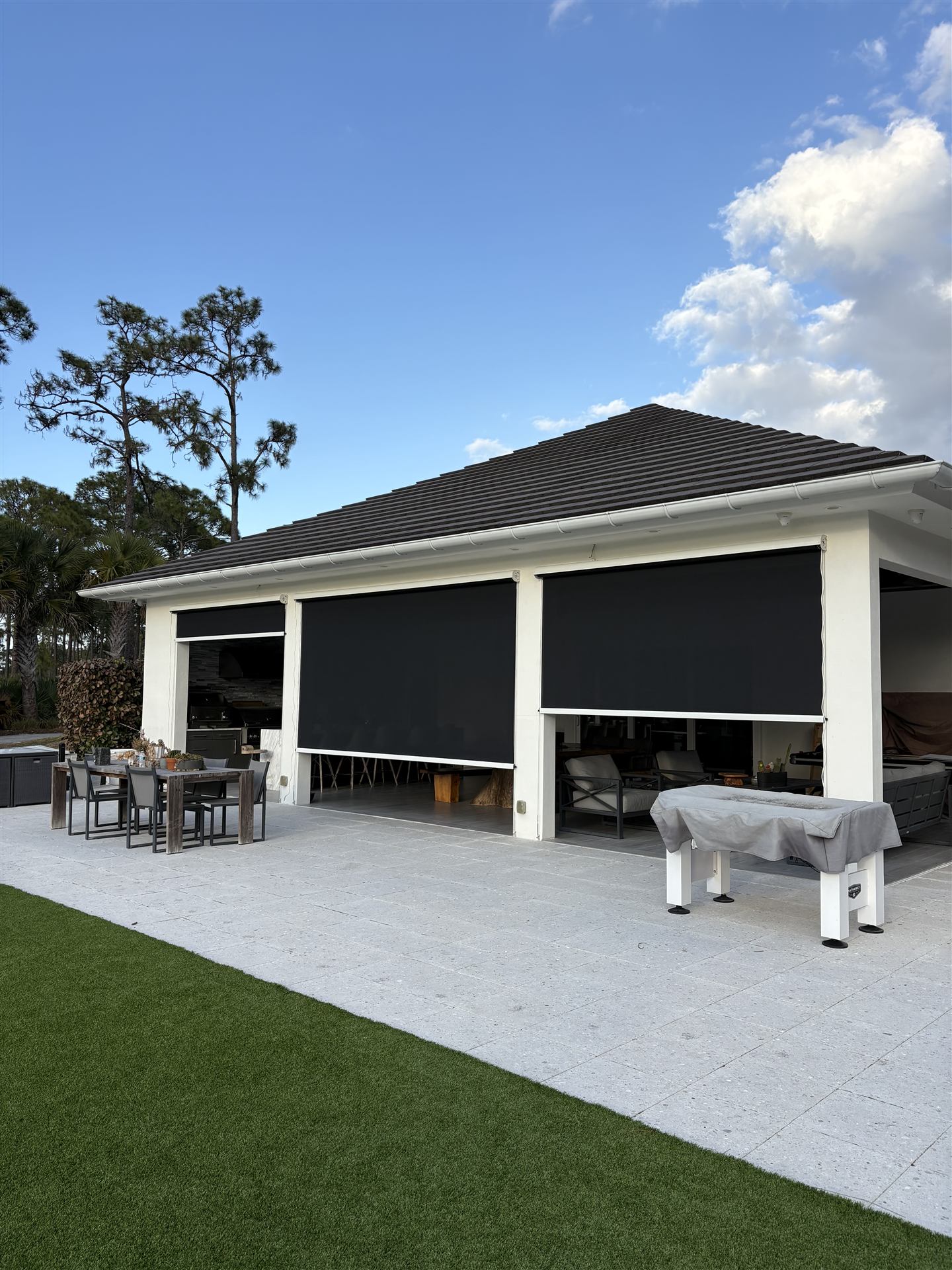 Electric roll-down screens deployed on a South Florida outdoor kitchen and patio