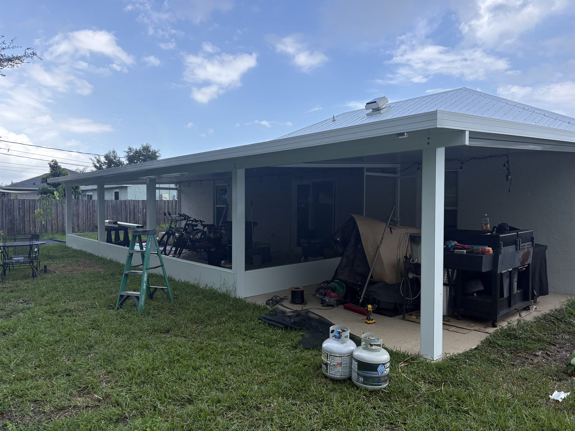 Long screened patio beneath a standing-seam aluminum roof
